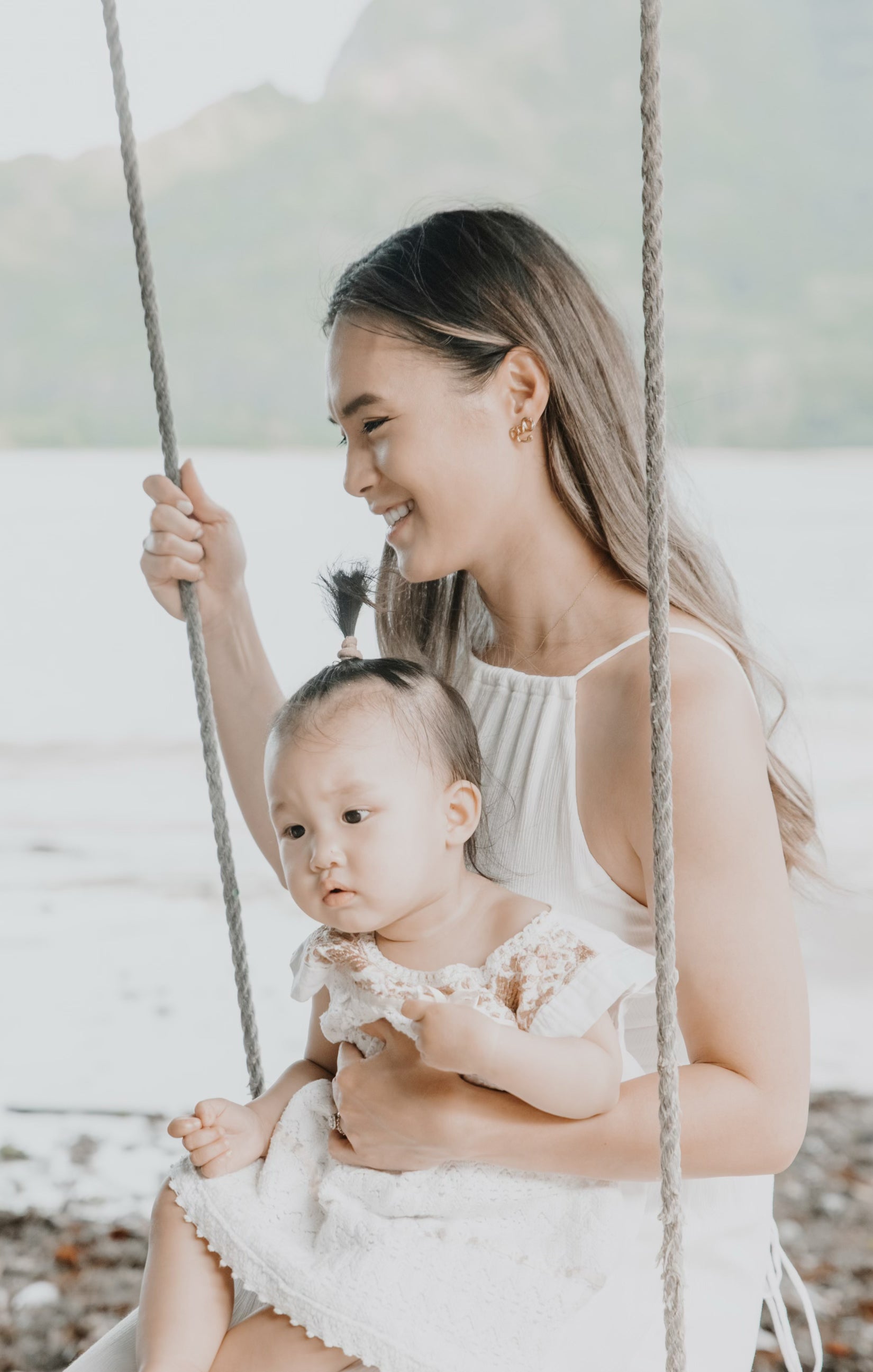 Photo of Jeannie holding baby Gemma on a swing